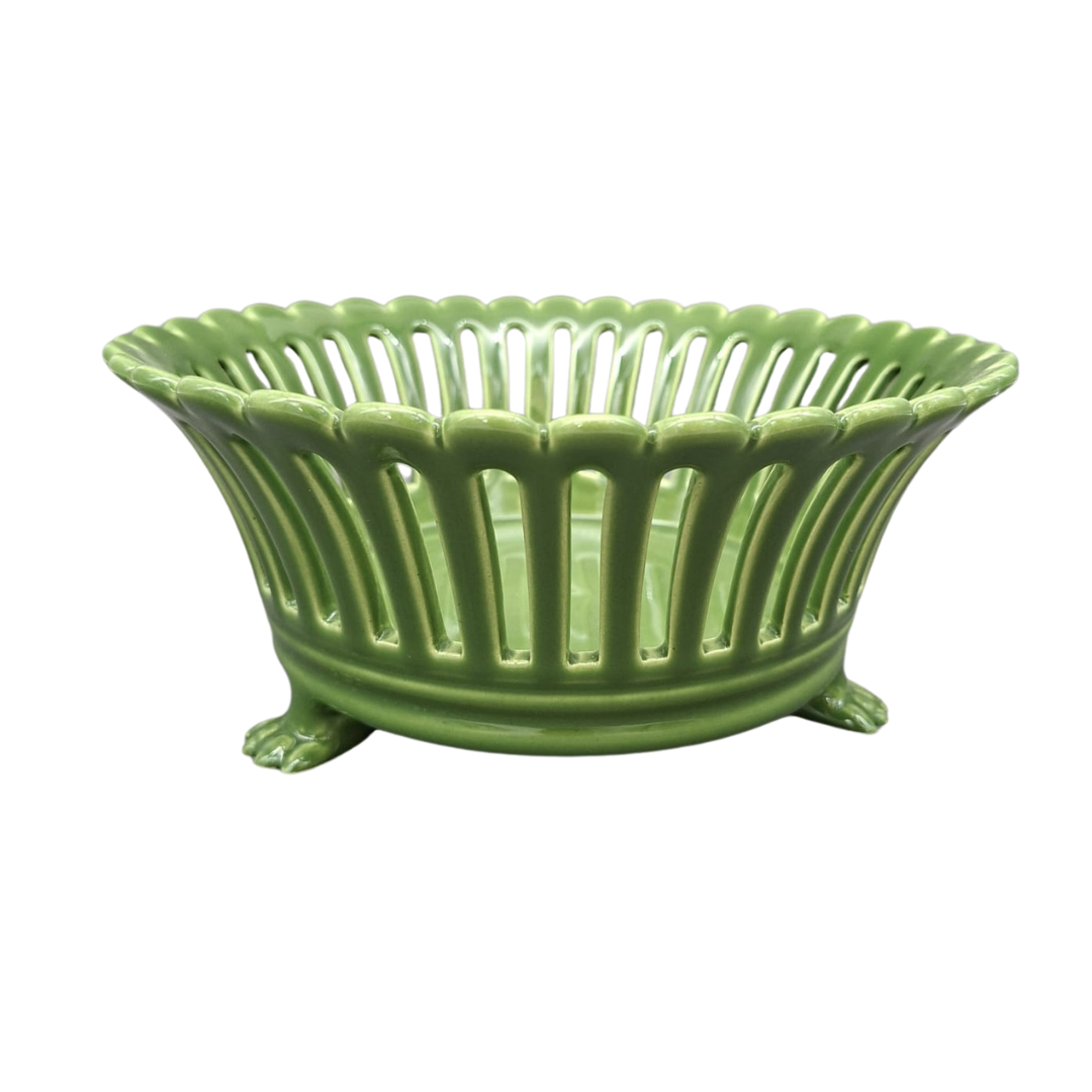 A green ceramic basket bowl with a fluted rim, vertical slotted sides, and three claw-like feet, shown on a plain white background.