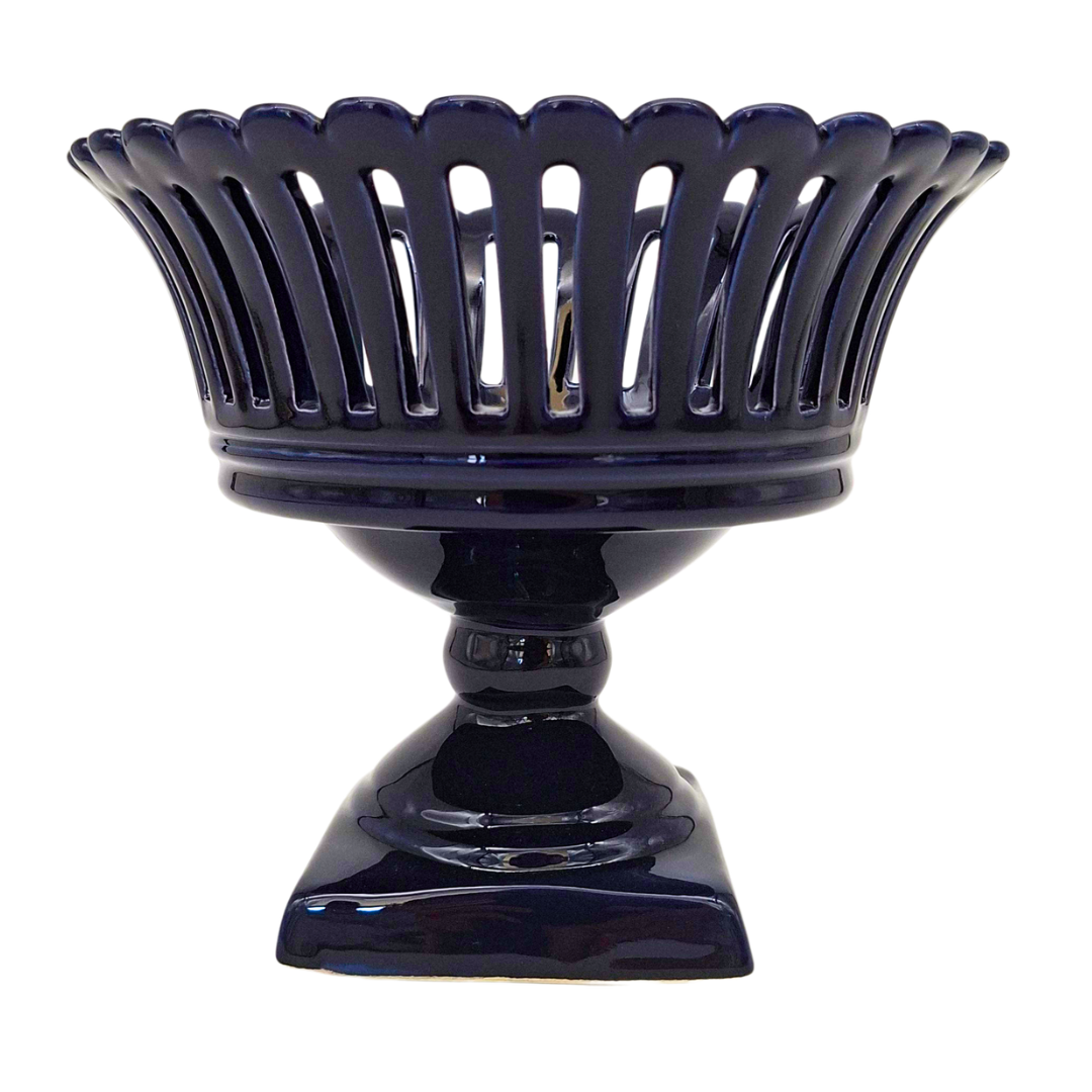 A glossy dark blue pedestal bowl with a fluted, scalloped rim and a square base, shown against a plain white background.