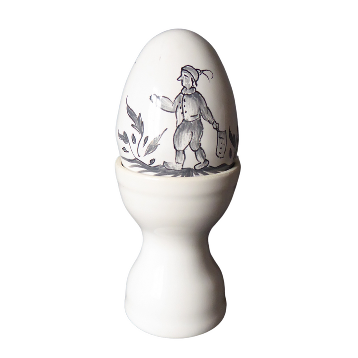 Double egg cup in white glaze shown with a hand painted egg