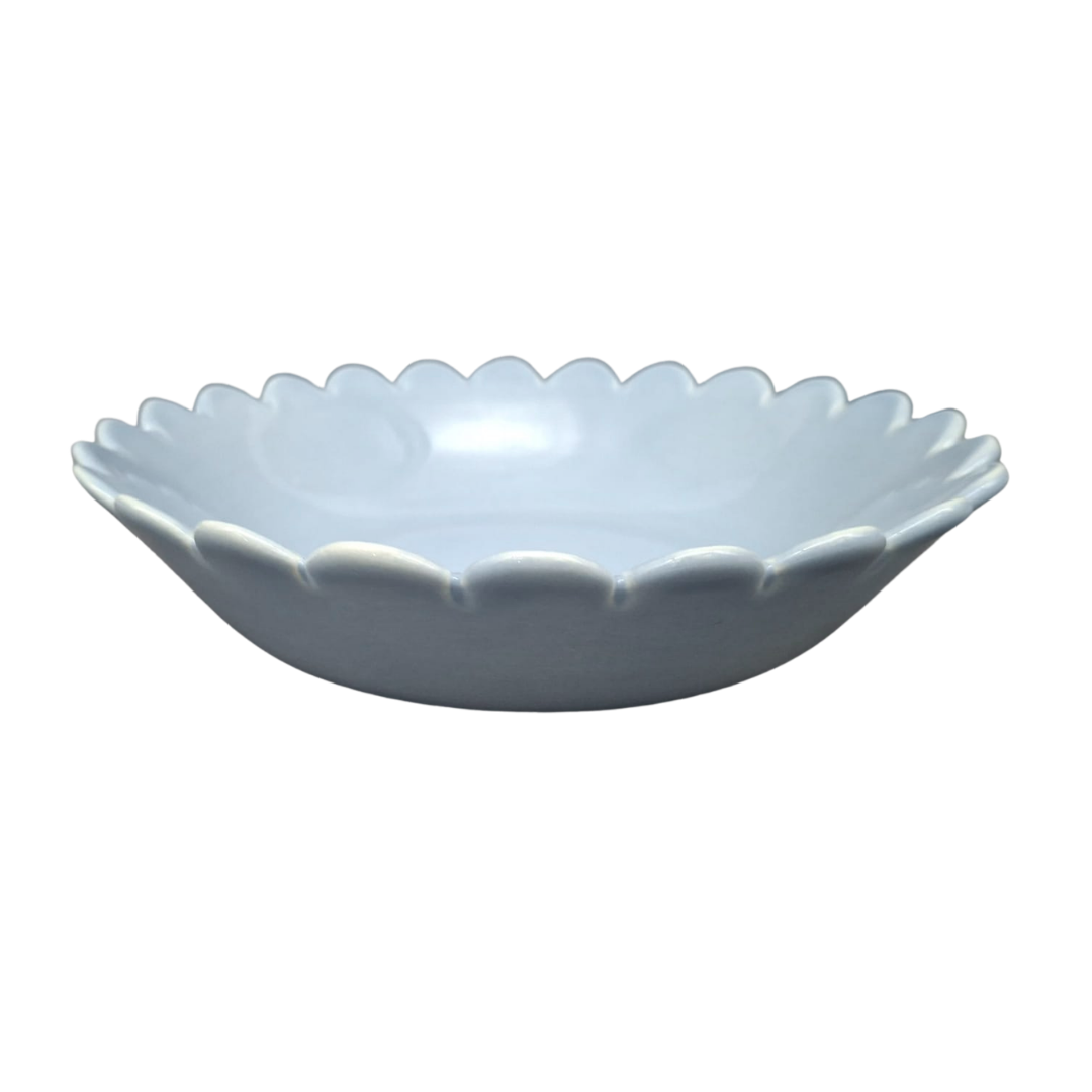A Dusty blue glazed ceramic shallow bowl with a delicate scalloped, petal-like rim, shown against a plain white background.