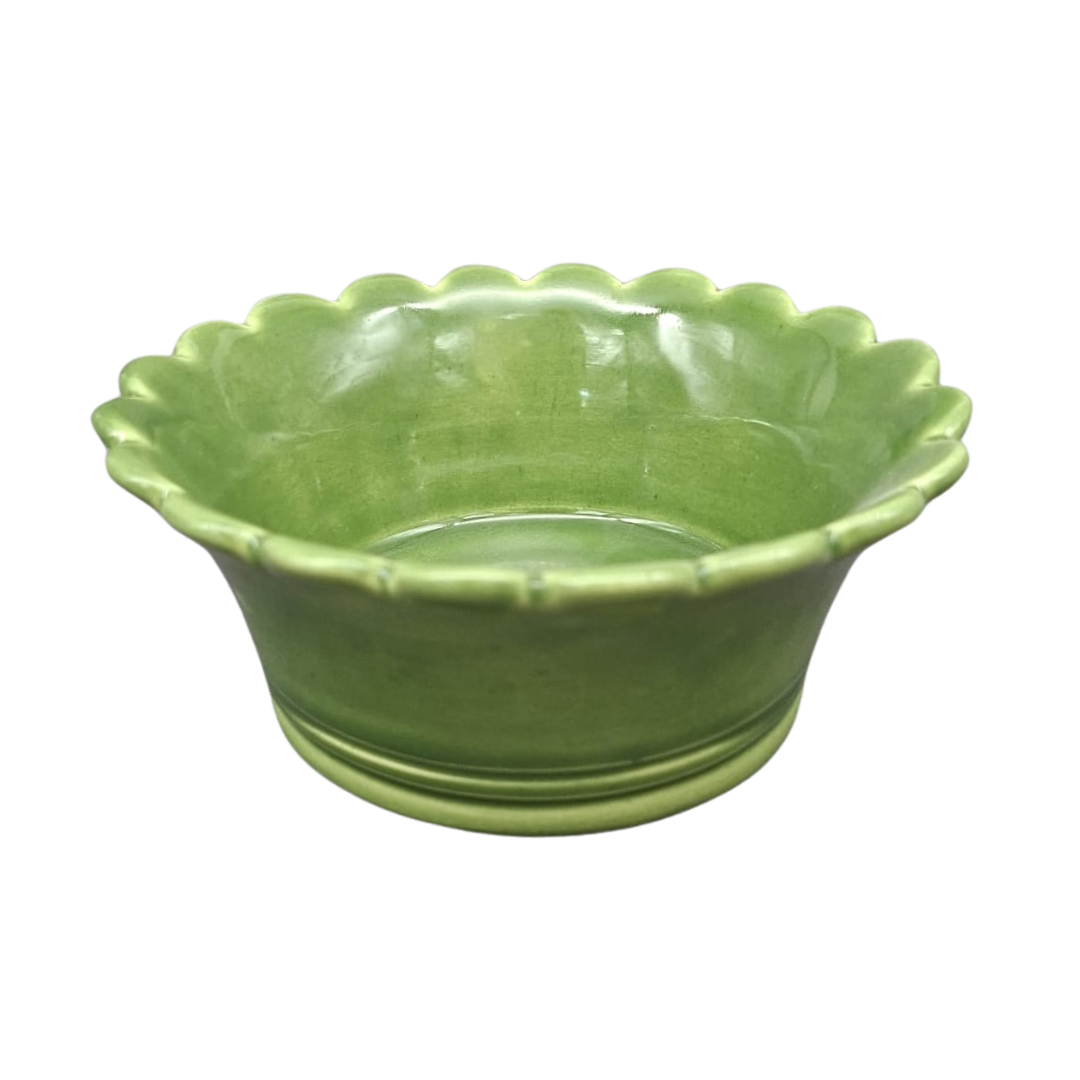 A small green ceramic bowl with a scalloped rim, shown on a plain white background.