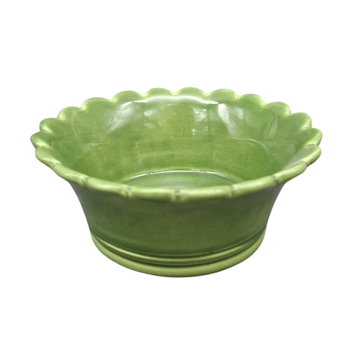 A small green ceramic bowl with a scalloped rim, shown on a plain white background.