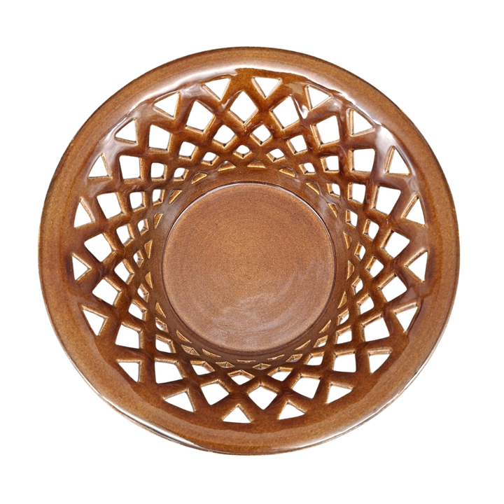 A round ceramic bowl with a brown lattice pattern on the outer rim, photographed from directly above on a white background.