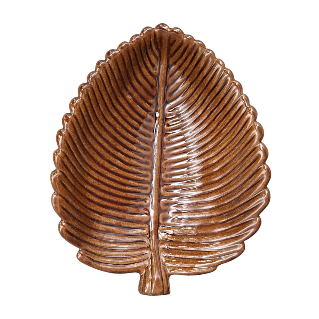 A decorative ceramic leaf-shaped dish in brown glaze with a raised central vein and ribbed texture, shown on a plain white background.