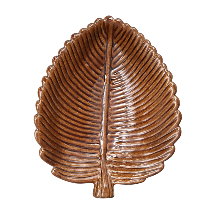 A decorative ceramic leaf-shaped dish in brown glaze with a raised central vein and ribbed texture, shown on a plain white background.
