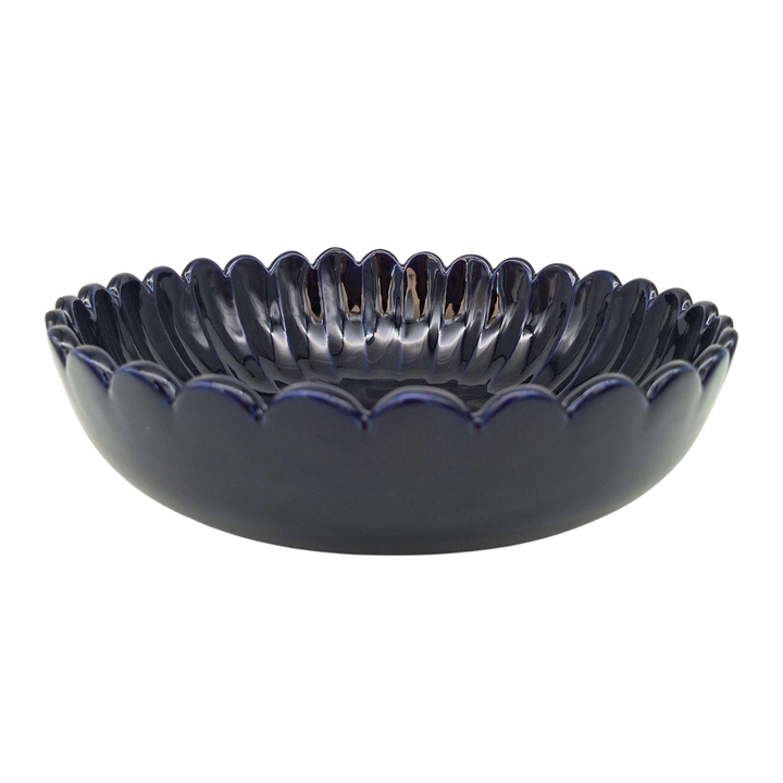 A dark navy blue ceramic bowl with a scalloped rim, shown against a plain white background.