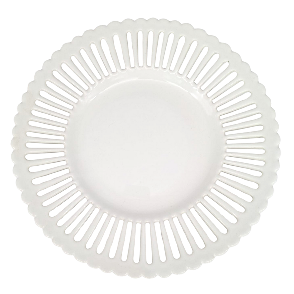 A white ceramic serving plate with a scalloped rim and a radial pattern of cutout slots, shown from a top-down view on a white background.