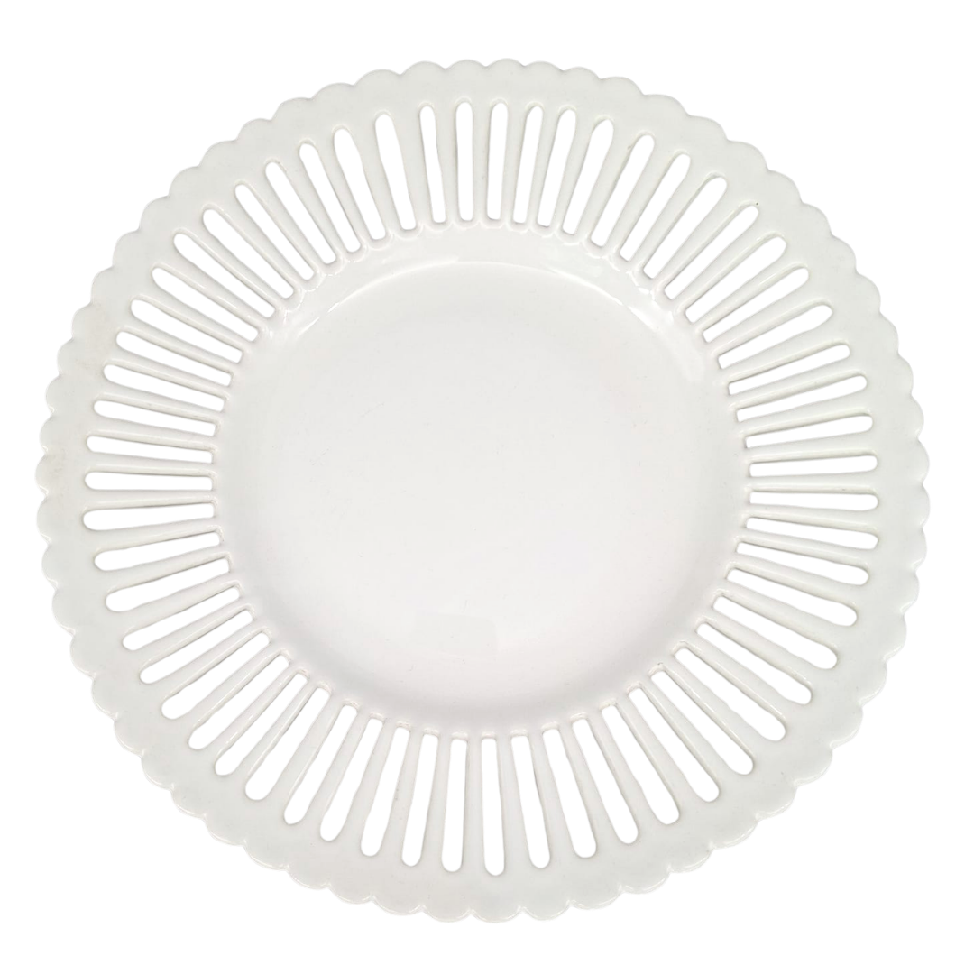 A white ceramic plate with a scalloped rim and a radial pattern of cutout slots, shown from a top-down view on a white background.