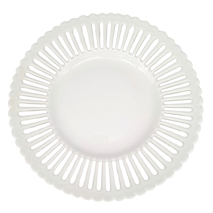 A white ceramic plate with a scalloped rim and a radial pattern of cutout slots, shown from a top-down view on a white background.